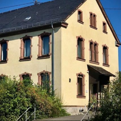 gelbes Pfarrhaus mit blauem Himmel