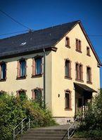 zweieinhalb stöckiges Haus mit Treppe im Vordergrund